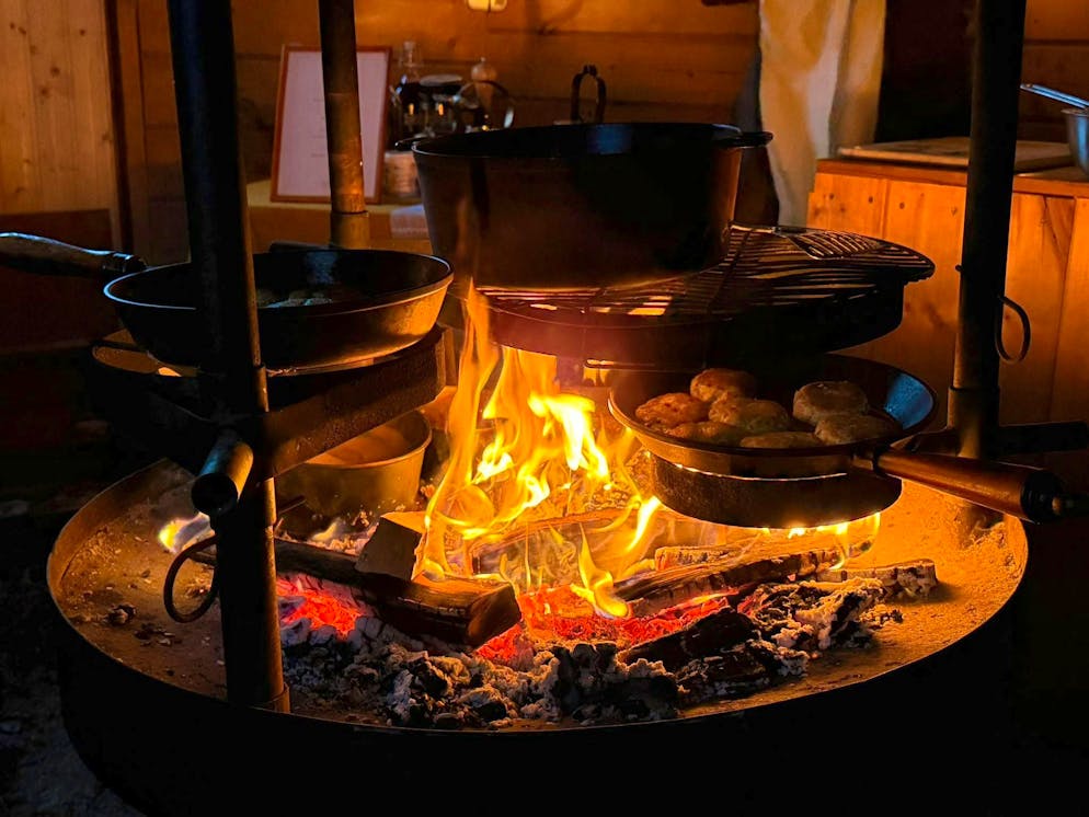 They cook with several pans over the fire.