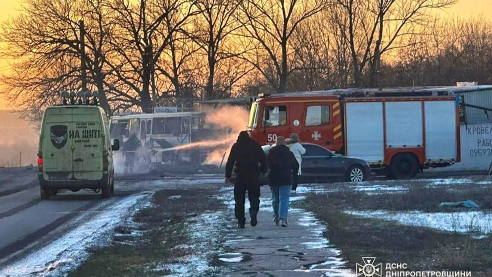 HANDOUT - Feuerwehrleute löschen das Feuer, nachdem eine russische Kampfdrohne einen mit Grubenarbeitern besetzten Bus getroffen hatte. Mindestens 15 Menschen wurden getötet. Foto: Uncredited/Ukrainian Emergency Service via AP/dpa - ACHTUNG: Nur zur redaktionellen Verwendung und nur mit vollständiger Nennung des vorstehenden Credits