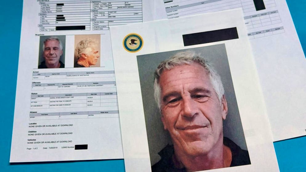 ARCHIV - Dokumente mit geschwärzten Passagen, die in den vom US-Justizministerium freigegebenen Jeffrey-Epstein-Akten enthalten sind, werden am Freitag, 2. Januar 2026, in Washington gezeigt und fotografiert. Foto: Jon Elswick/AP/dpa - ACHTUNG: Nur zur redaktionellen Verwendung im Zusammenhang mit der aktuellen Berichterstattung und nur mit vollständiger Nennung des vorstehenden Credits