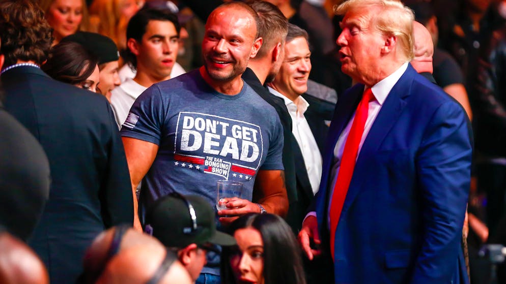 Dan Bongino (Mitte) trifft am 11. November 2023 im New Yorker Madison Square Garden Donald Trump bei einem UFC-Kampf.
