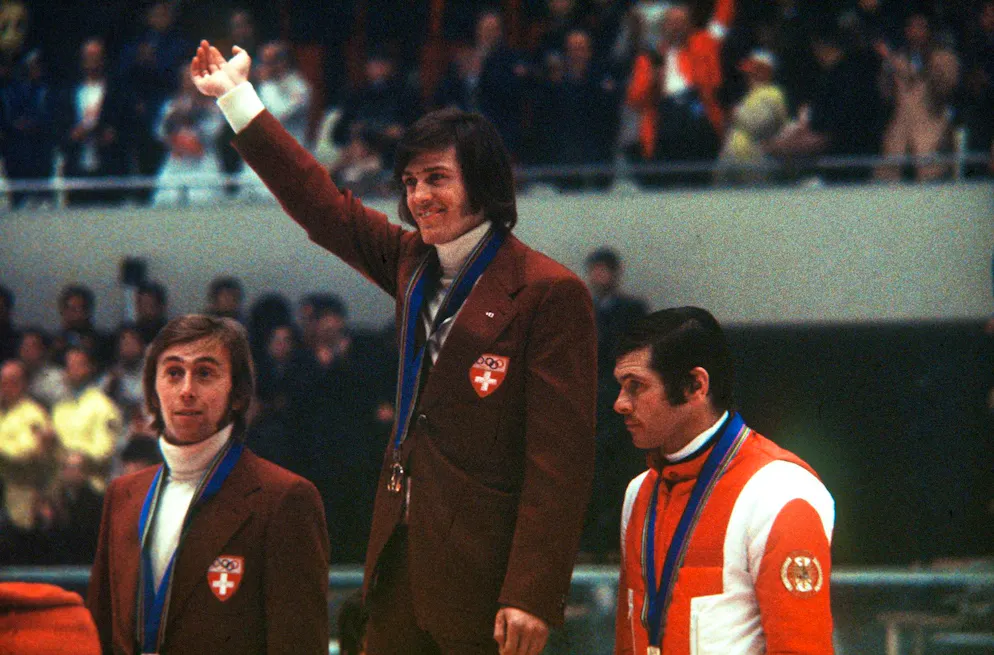Das sind die Schweizer Abfahrts-Olympiasieger. Siegerehrung der Herren-Abfahrt an den Olympischen Winterspielen in Sapporo, Februar 1972. Gold und Silber gewannen die beiden Schweizer Bernhard Russi, Mitte, und Roland Collombin, links, Bronze ging an Heinrich Messner, rechts, aus Österreich. (KEYSTONE/Str)