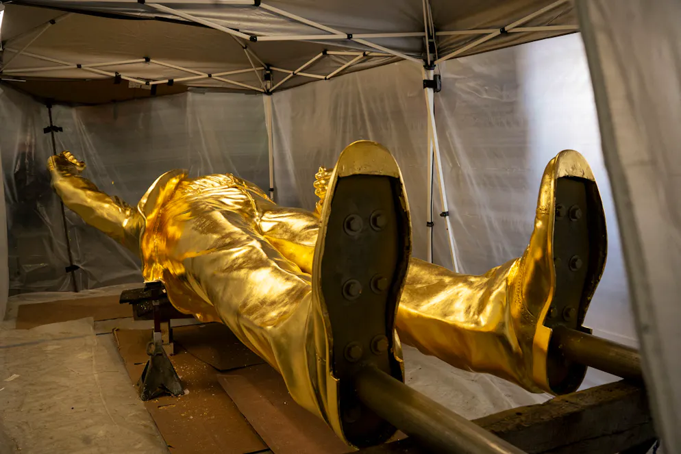 La statue en bronze de 4,6 mètres recouverte d'une épaisse couche de feuilles d'or représentant le président américain Donald Trump repose dans l'atelier du sculpteur Alan Cottrill à Zanesville, dans l'Ohio, le 5 février 2026.
