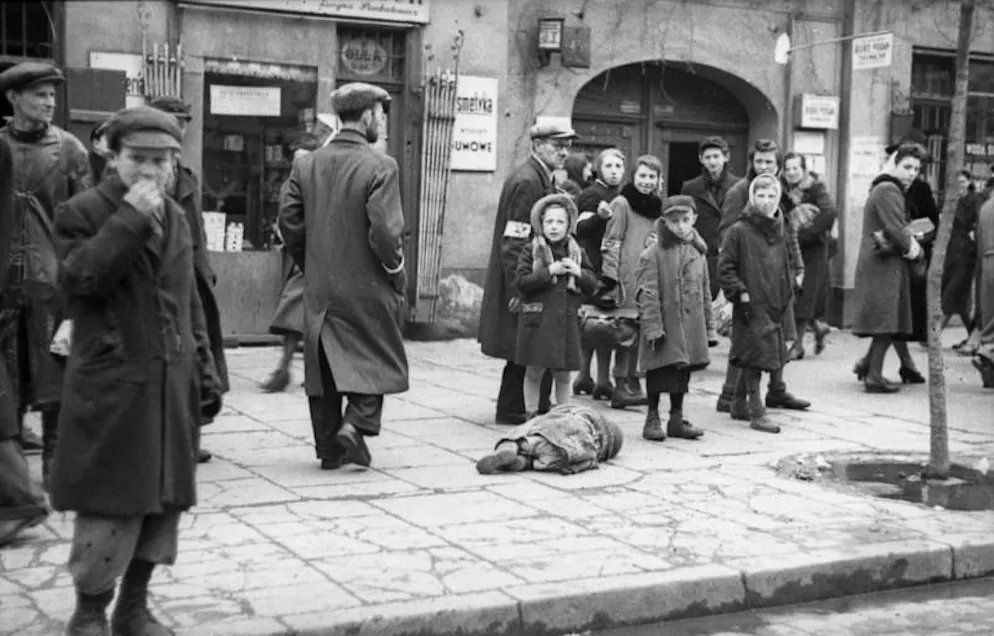 Ein Kind liegt auf einem Trottoir im Warschauer Ghetto. Die Aufnahme entstand im Mai 1941 durch einen Angehörigen der deutschen Propagandakompanie 689.