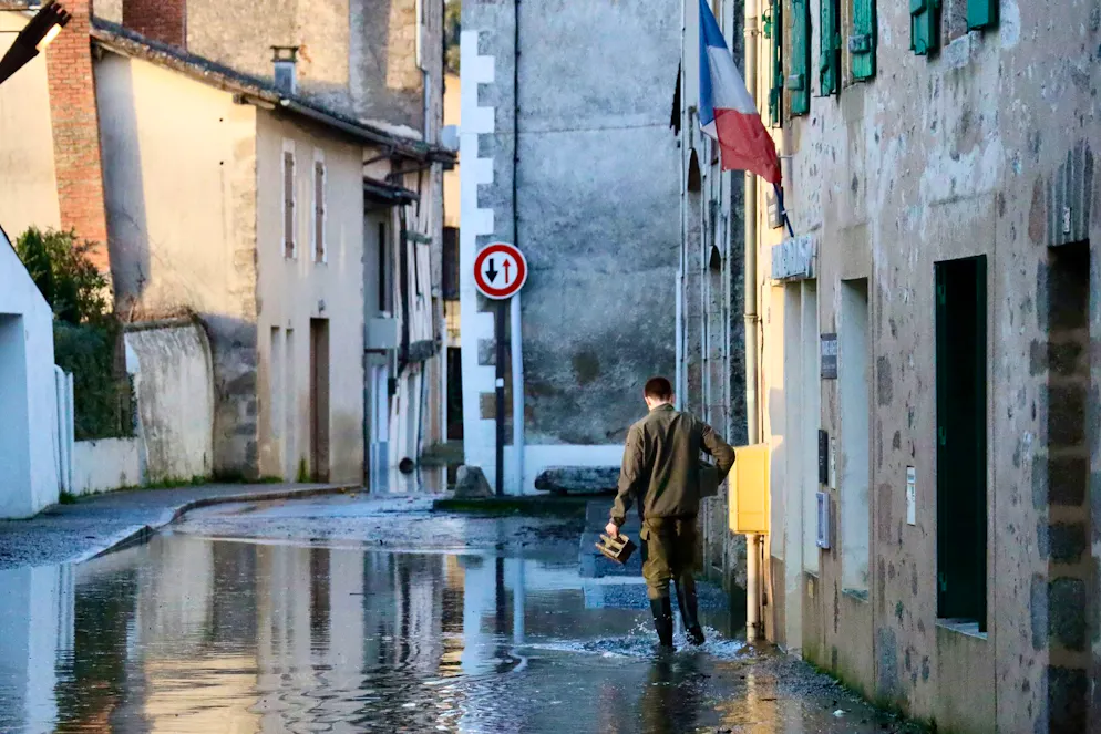 Un homme marche dans une rue inondée de Saint-Germain-de-Confolens alors que de graves inondations frappent l'ouest de la France sous l'effet de la tempête Nils, jeudi 12 février 2026. (AP Photo/Yohan Bonnet)
