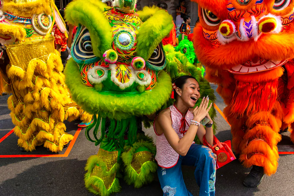 2026: Capodanno cinese sotto il segno del cavallo. Una festaiola si fa fotografare con i danzatori di leoni nella Chinatown di Bangkok. Il Capodanno cinese si celebra il 17 febbraio 2026, inaugurando l'Anno del Cavallo.
