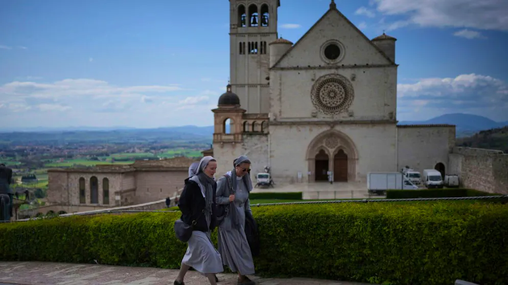 ARCHIV - Nonnen gehen an der päpstlichen Basilika und dem Kloster des Heiligen Franz von Assisi in Assisi vorbei. Foto: Alessandra Tarantino/AP/dpa