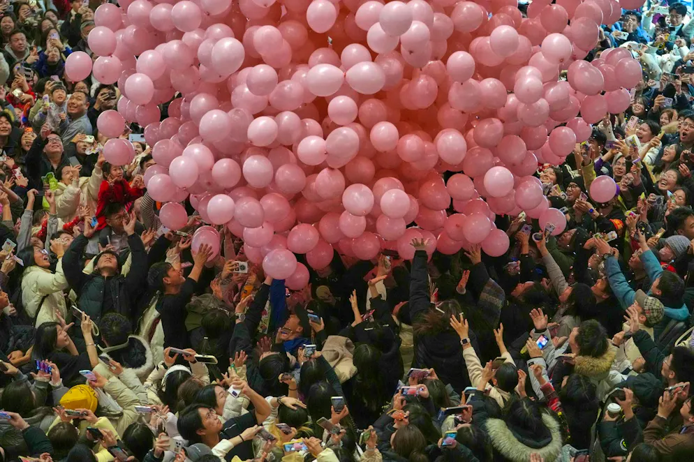 2026: Capodanno cinese sotto il segno del cavallo. Festeggiati riprendono e catturano i palloncini che cadono durante il conto alla rovescia per il passaggio all'anno 2026 in un centro commerciale di Pechino.