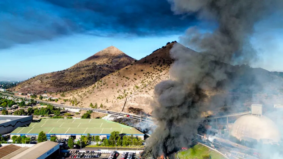Rauch steigt in den Himmel, nachdem ein mit Flüssiggas beladener Tanklaster in einem Industriegebiet nahe Santiago de Chile umkippte und explodierte. Foto: Hans Scott/Agencia Uno/dpa