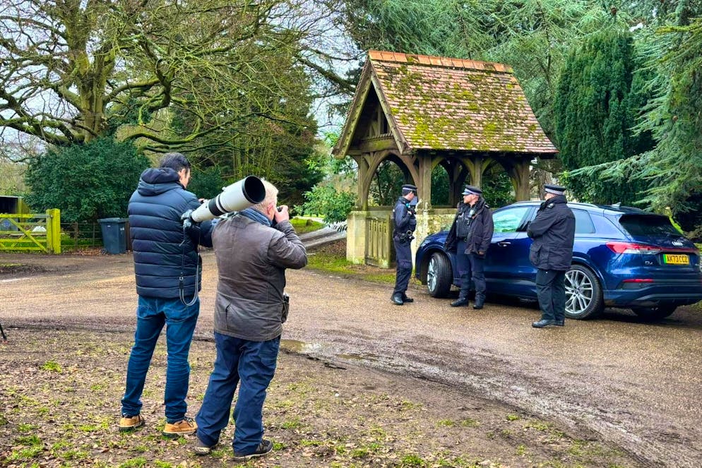 Members of the media have gathered in front of the gate.