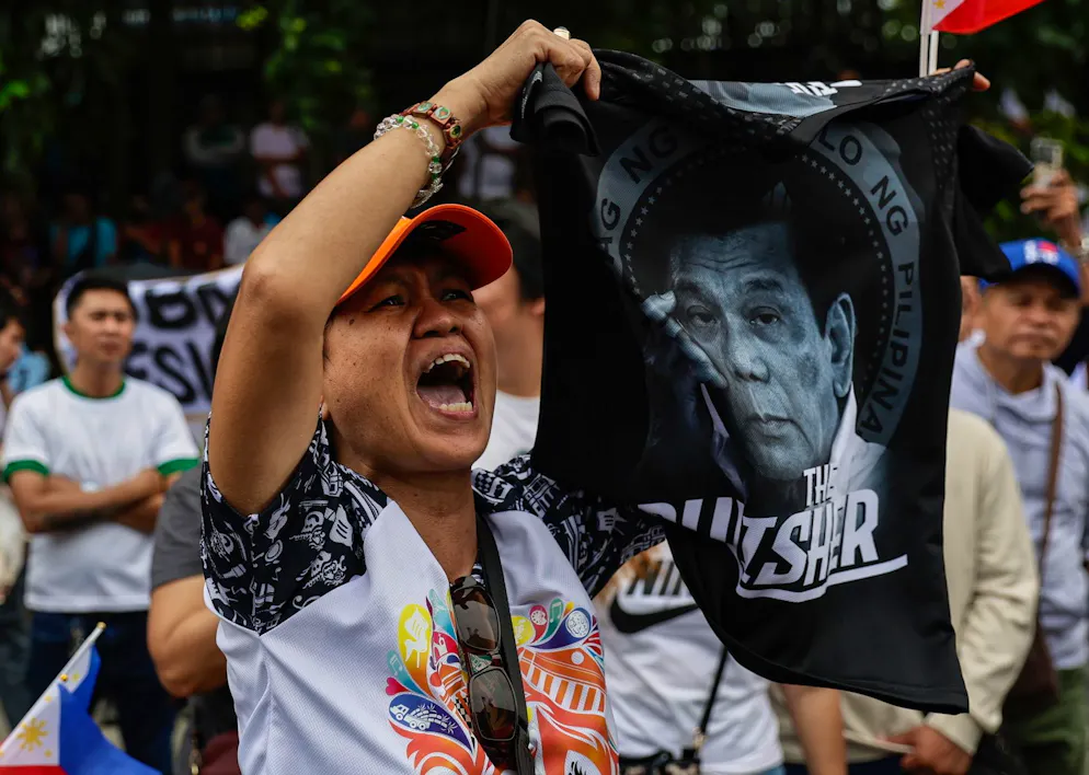 Un manifestant réclamant la démission du président philippin Ferdinand « Bongbong » Marcos Jr. brandit un t-shirt à l'effigie de l'ancien président Rodrigo Duterte lors d'un rassemblement anti-corruption à Quezon City, dans la métropole de Manille, aux Philippines, le 16 novembre 2025.
