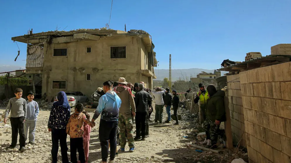 Menschen versammeln sich an einem zerstörten Gebäude, das bei einem israelischen Luftangriff in dem Dorf Temnine in der Bekaa-Ebene getroffen wurde. Bei dem Angriff wurden zehn Menschen getötet, darunter acht Hisbollah-Kämpfer. Foto: Marwan Naamani/dpa