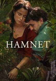 Ein Mann und eine Frau in historischer Kleidung lehnen eng aneinander inmitten dichter grüner Farne und Pflanzen.