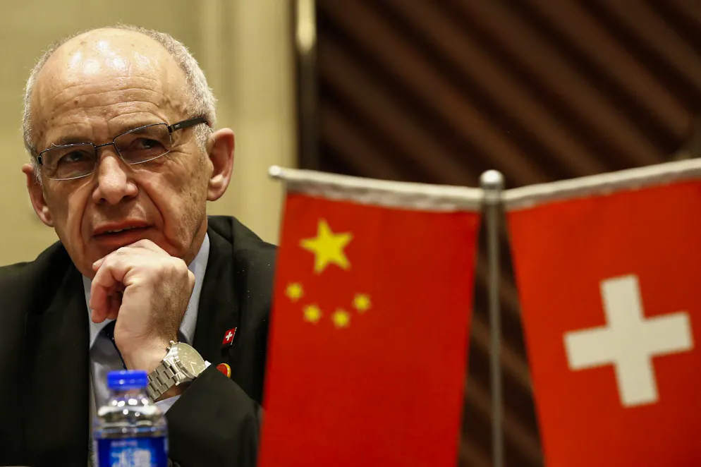 Schnitzelbängg 2026 Schweiz. Was fange au d Chinese mit däm Ueli Murer aa? <br>Dert trifft är jo am liebste numme Pest und Cholera <br>Doo het är sich politisch gsee in epis bleeds verstriggd <br>Drum hän s en denn vo Temu wieder gratis Heime gschiggd. <br><br>(Frau Länzli)