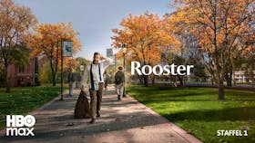 Ein zerzauster Mann mit offener Krawatte und Sakko in der Hand geht ratlos über einen herbstlichen Universitätscampus mit bunten Bäumen.