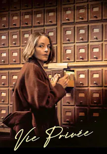 Jodie Foster im braunen Mantel blickt über die Schulter, während sie eine Schublade in einem riesigen Archivschrank öffnet.