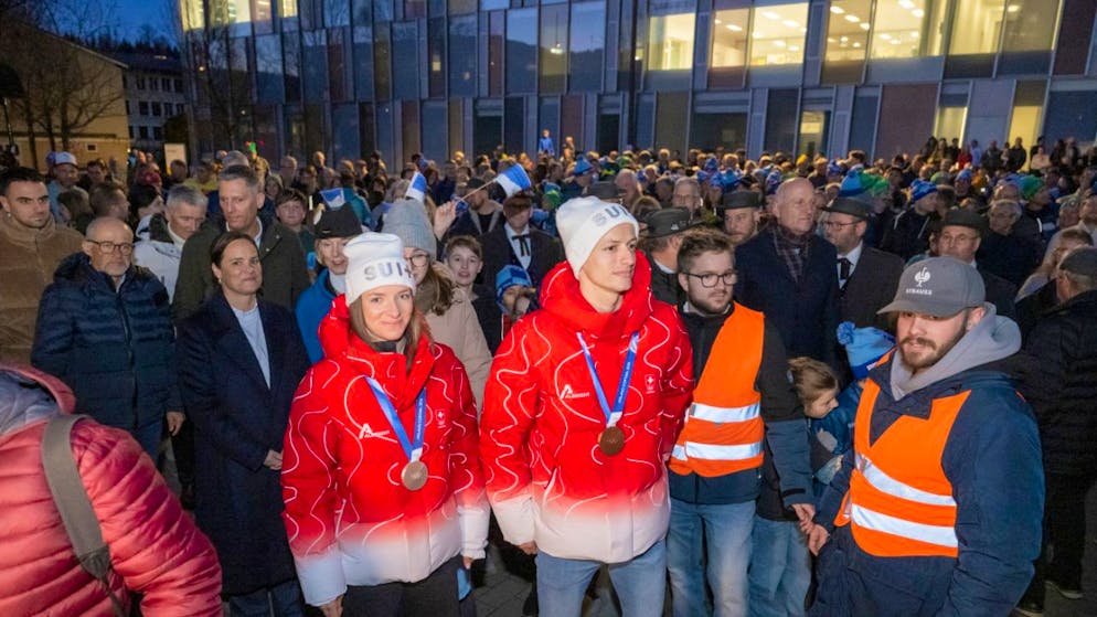 Nadine Fähndrich (links) und Gregor Deschwanden mit ihren Olympia-Medaillen beim Einzug in die Mehrzweckhalle von Horw, wo sie dem Skiclub angehören.