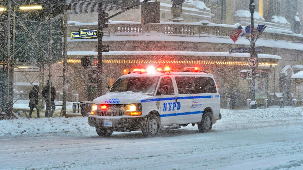A New York Police Department vehicle fights its way through a winter storm.