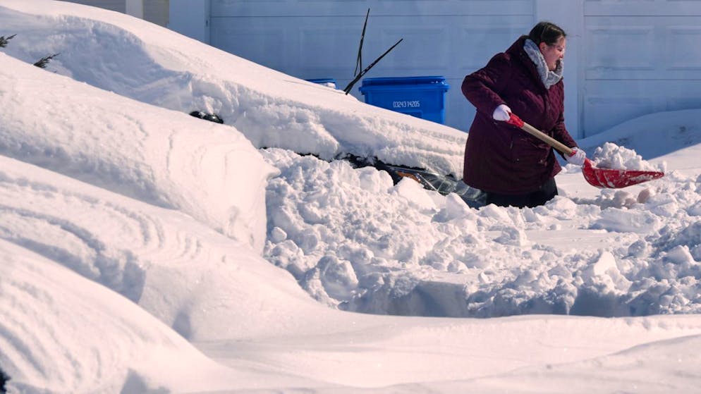Une femme déblaie sa voiture à Cranston, dans l'Etat de Rhode Island. Avec celui du Massachusetts, ce sont les Etats qui ont été les plus touchés, avec plus de 90 cm de neige tombés par endroits.