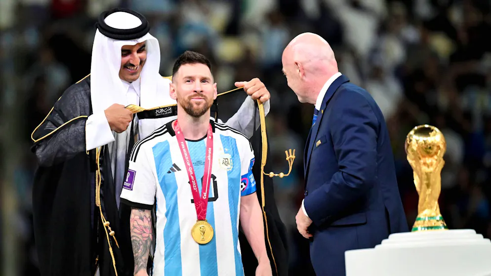 Der Emir von Katar legt Lionel Messi ein spezielles Gewand um.