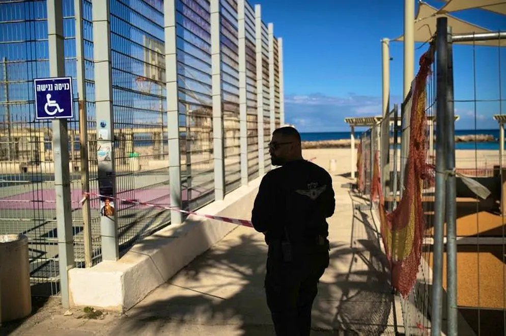 USA and Israel attack Iran. A policeman blocks off the beach promenade in Haifa after sirens were sounded in the port city.