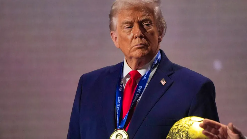 Donald Trump stands in front of the World Cup trophy