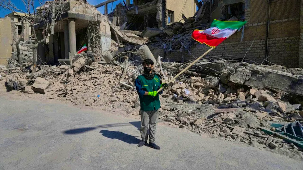 dpatopbilder - A boy waves an Iranian flag in front of a police facility that was hit during the US-Israeli military action. Photo: Vahid Salemi/AP/dpa