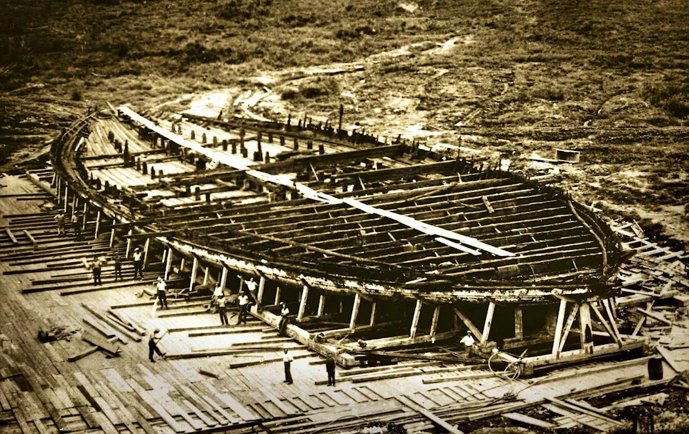 The enormous hull of a Nemi ship is exposed after the lake has sunk. Workers secure the ancient construction (1928).