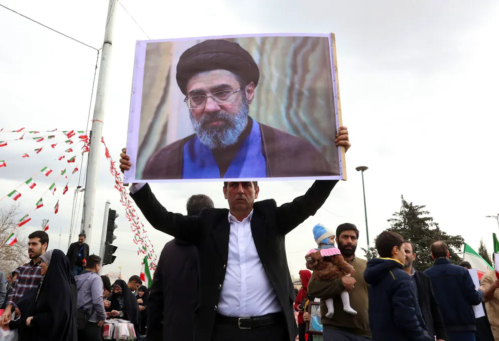 Seconda settimana di guerra contro l'Iran. Un uomo iraniano tiene in mano una foto di Mojtaba Khamenei mentre partecipa alle celebrazioni per il 47° anniversario della Rivoluzione Islamica a Teheran l'11 febbraio 2026.