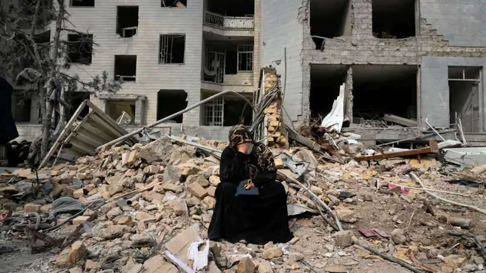 Eine Frau sitzt auf den Trümmern eines Wohnhauses, das am vergangenen Montag während der amerikanisch-israelischen Luftangriffe beschädigt wurde. Foto: Vahid Salemi/AP/dpa