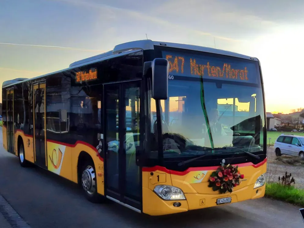 Ein Postauto mit Blumenschmuck in der Region Kerzers.