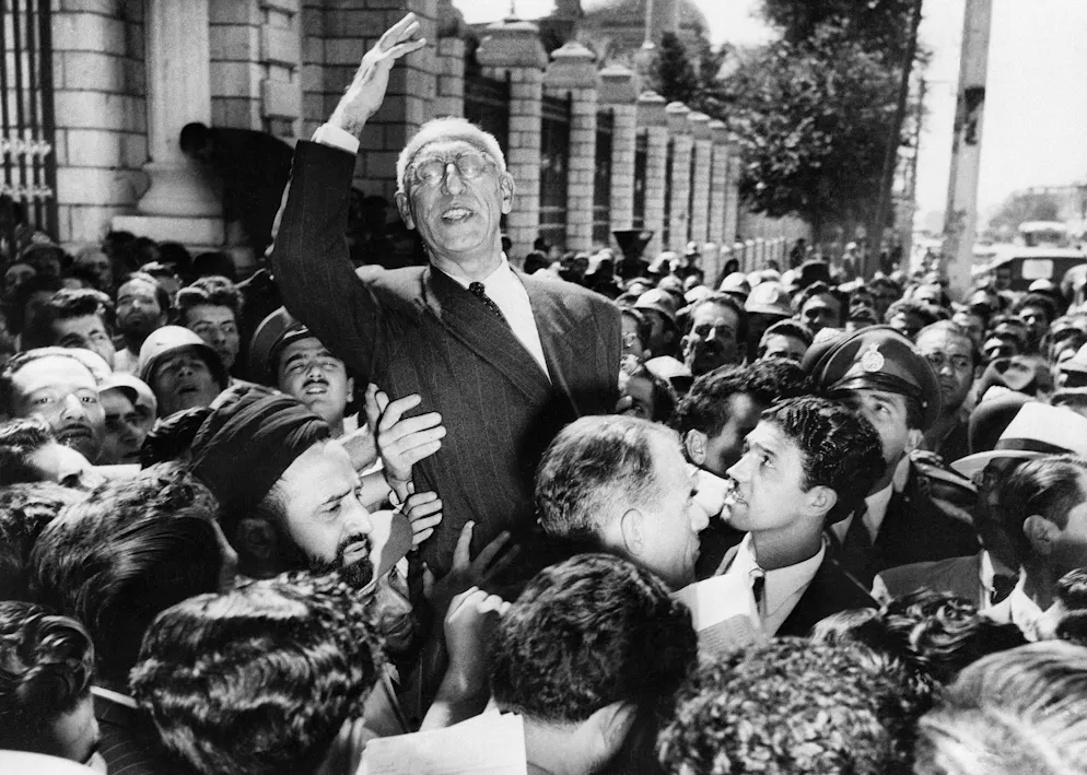 Septembre 1951 : des partisans en liesse portent le Premier ministre Mohammad Mossadegh sur leurs épaules sur la place du Majlis devant le bâtiment du Parlement à Téhéran. Il vient de réitérer sa demande de nationalisation de l'industrie pétrolière.