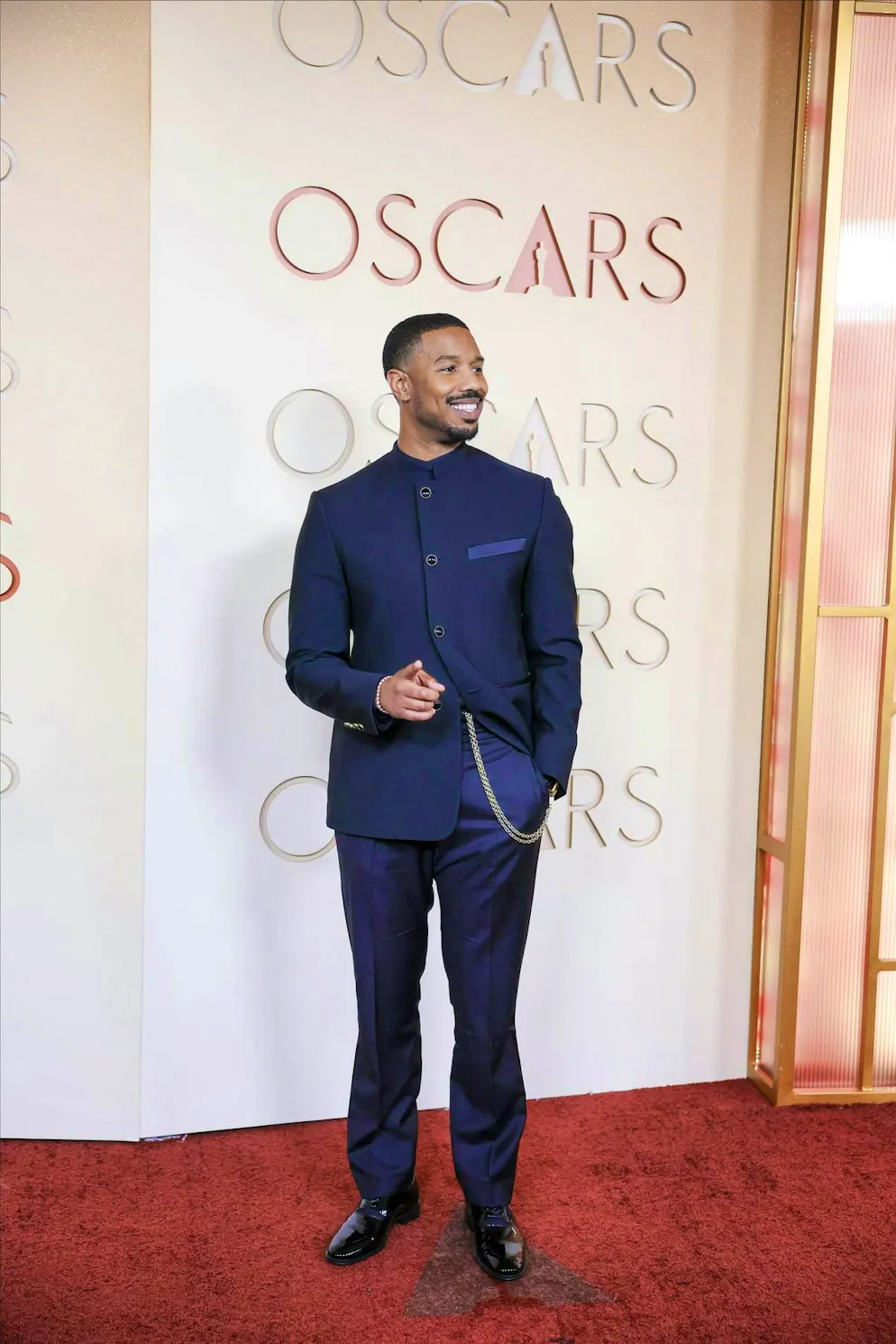 Oscar 2026: i migliori abiti del red carpet. Michael B. Jordan ha riscoperto la sua catena hip degli anni '90, ma lo stile hip-hop? Non se ne parla. Invece, il dettaglio spezza l'abito altrimenti molto classico.