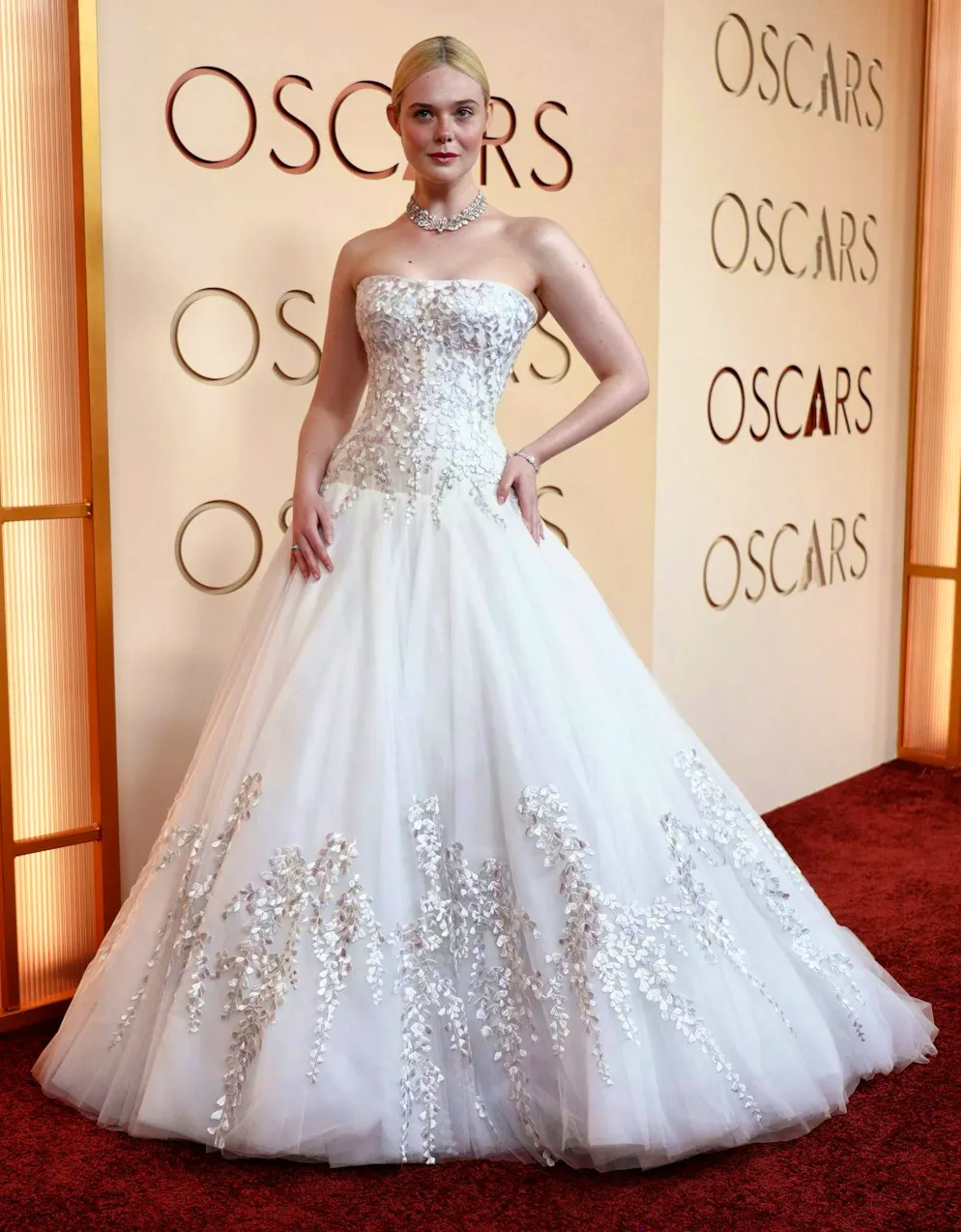 Oscar 2026: i migliori abiti del red carpet. Un matrimonio? Elle Fanning non ne ha bisogno per apparire in un abito da ballo bianco da principessa. L'abito opulento: diamanti, ovviamente.
