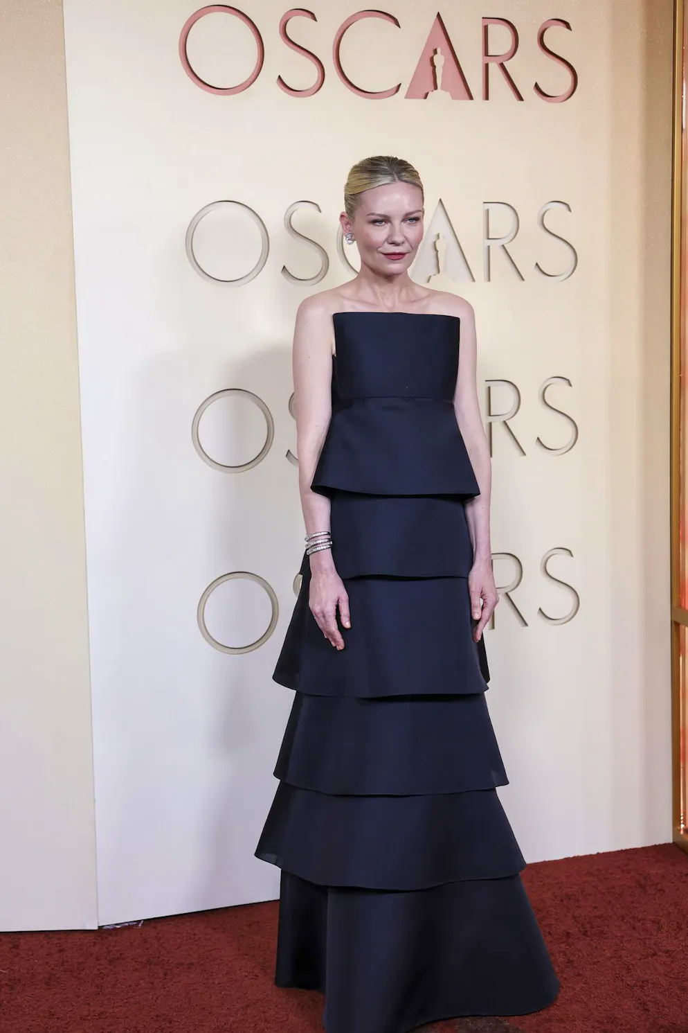 Oscars 2026: Die besten Outfits vom roten Teppich. Schauspielerin Kirsten Dunst lieferte im Tiered Dress eine architektonische Silhouette und trifft ins Schwarze.