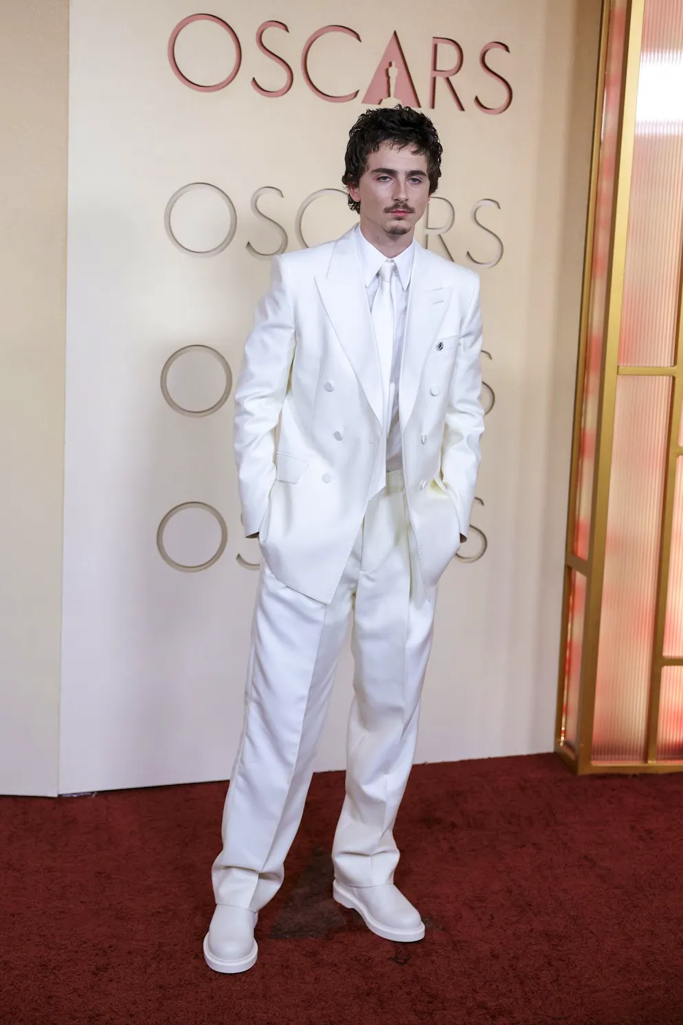 Oscars 2026: Die besten Outfits vom roten Teppich. Timothée Chalamet trägt ebenfalls Weiss – im konsequenten Monochrom-Look setzt der Schauspieler ein Statement. Besonders ins Auge fallen die geschlossenen, weissen Boots.