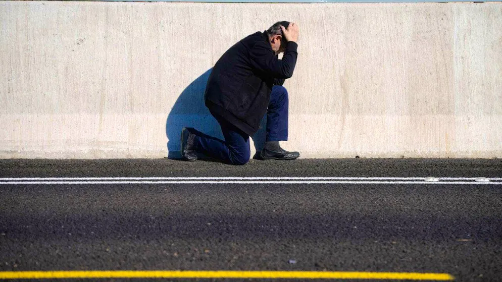dpatopbilder - A man takes cover on the side of the road as an air raid siren warns of an imminent Iranian rocket attack in Tel Aviv. Photo: Ohad Zwigenberg/AP/dpa
