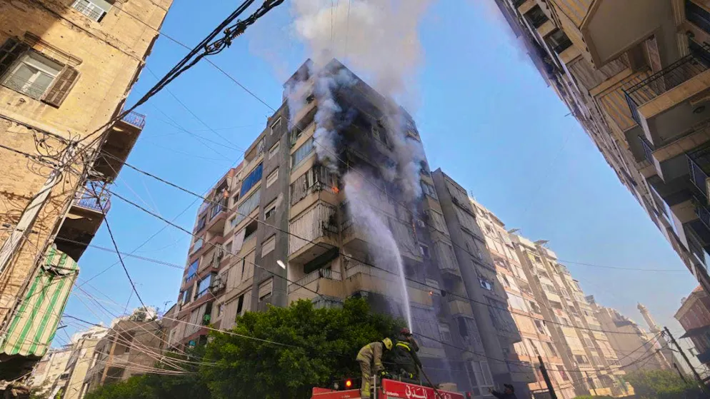 Firefighters spray water on a burning apartment building after an Israeli airstrike in the center of the Lebanese capital. Photo: Hassan Ammar/AP/dpa