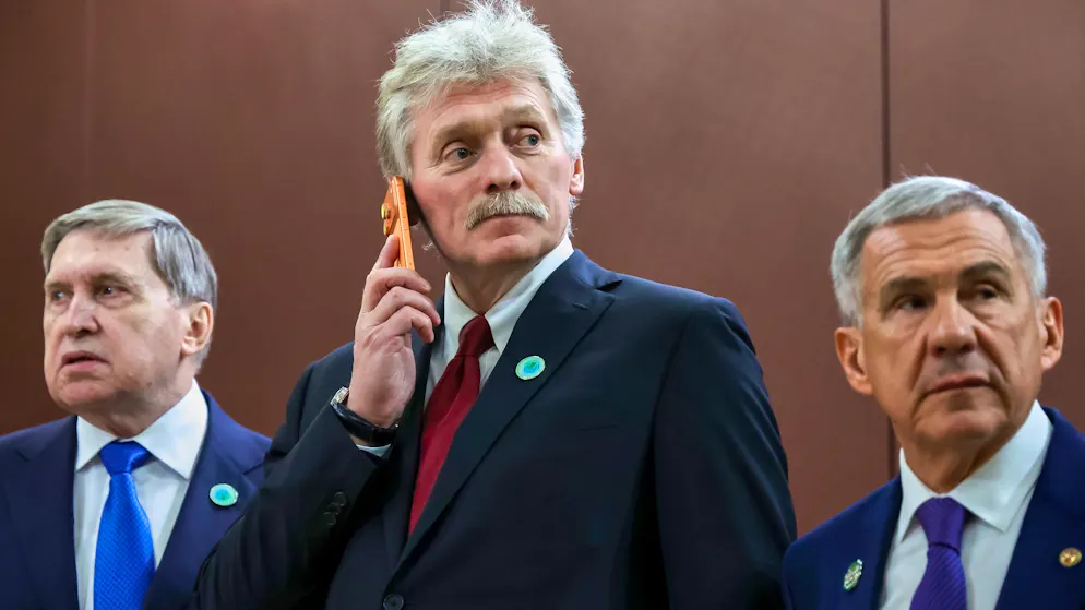 Kreml-Sprecher Dmitri Peskow telefoniert – eingerahmt vom aussenpolitischen Berater Juri Uschakow (links) und Rustam Minnichanow, dem Präsidenten der russischen Teilrepublik Tarstastan. Ein Schnappschuss aus Aschgabat, Turkmenistan, vom 12. Dezember 2025.