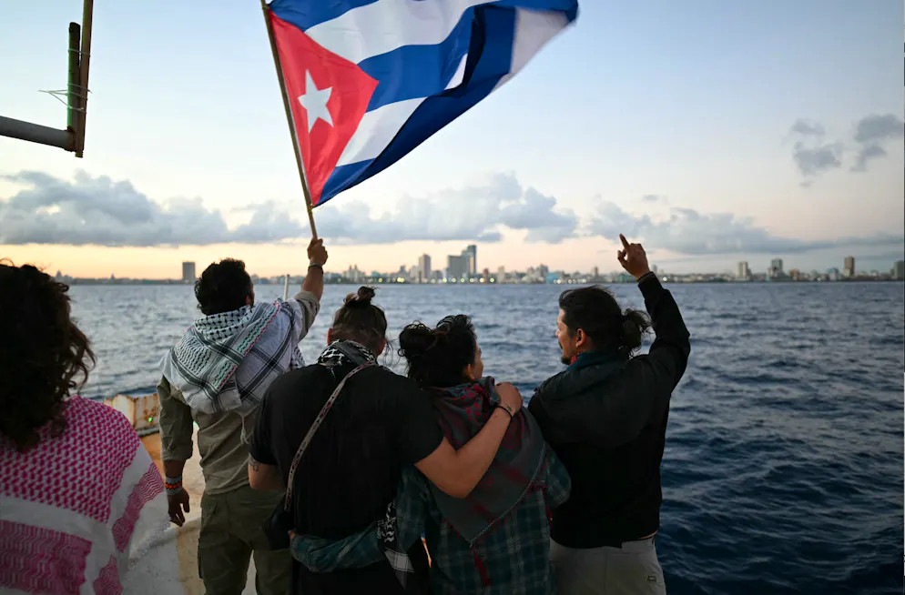 Un activiste brandit un drapeau cubain à bord du navire Maguro, arrivé du Mexique avec une aide humanitaire dans le cadre du convoi Nuestra América, en accostant au port de La Havane le 24 mars 2026.