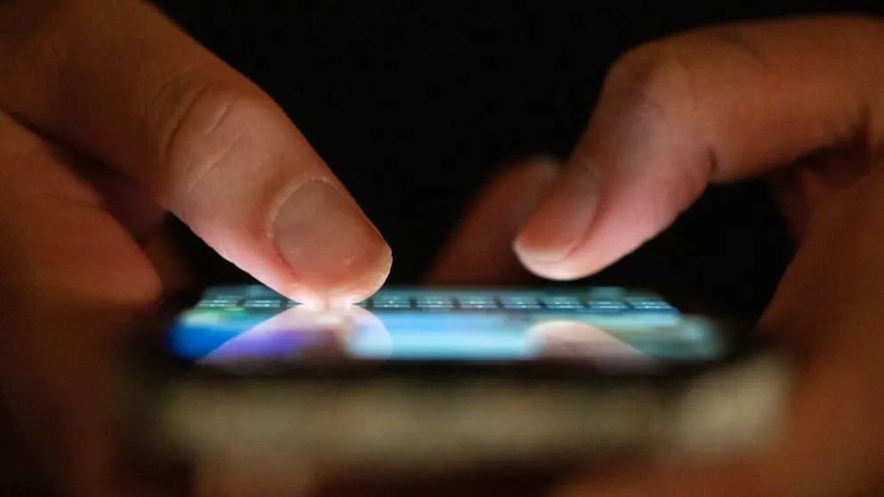 ILLUSTRATION - Eine Frau tippt auf einem Smartphone. (zu dpa: «Kinderpornografie: EU-Parlament stimmt gegen «Chatkontrolle»») Foto: Sebastian Kahnert/dpa