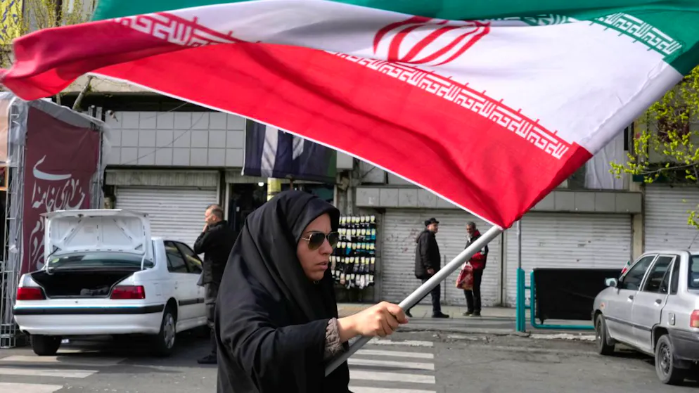 ARCHIV - Eine Frau schwenkt eine iranische Flagge während einer Kundgebung zur Unterstützung der Regierung auf dem Enqelab-e-Eslami-Platz (Platz der Islamischen Revolution). Foto: Vahid Salemi/AP/dpa