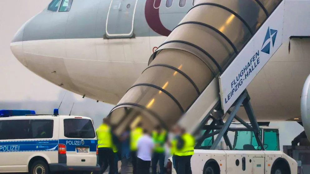 ARCHIVE - People board a Qatar Airways plane on the apron at Leipzig/Halle Airport, with federal police vehicles standing in front of it. (to dpa: "Almost two thirds of all planned deportations failed") Photo: Jan Woitas/dpa - ATTENTION: Person(s) has/have been pixelated for legal reasons