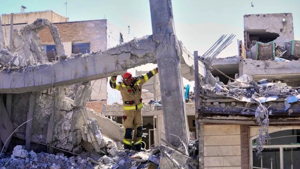 dpatopbilder - A first responder inspects the damaged structure of an apartment building hit in an earlier US-Israeli attack. Photo: Vahid Salemi/AP/dpa