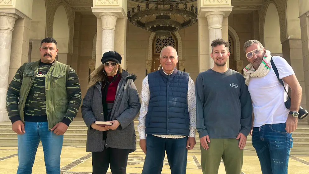 Mosque. Behind the scenes: The army officer responsible for the facility, the representative of the Ministry of Tourism, the local guide - and two journalists from Switzerland. A group picture that shows: The new capital is also a political and media project.