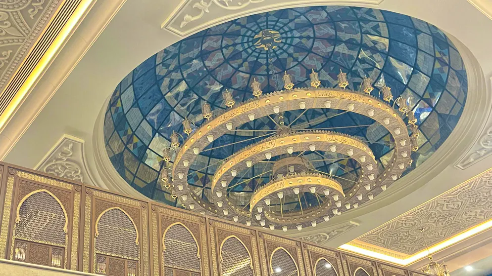 Mosque. Light as staging: the monumental chandelier under the dome is a central element - multi-level, circular and with hundreds of lamps. It bathes the room in warm light and enhances the effect of the already gigantic dimensions.