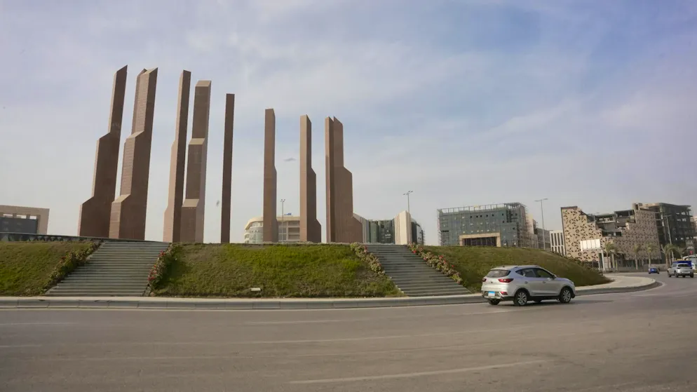 Government district. A huge traffic circle in front of the bank buildings - designed for traffic that isn't even there yet. Only a few cars, lots of space, lots of emptiness. The new capital is built for the future - but in everyday life it still lacks dynamism. Instead, symbolic gestures dominate.