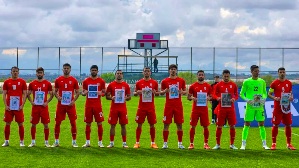The Iranian players with pictures of children who, according to the Iranian delegation, were killed in the war.