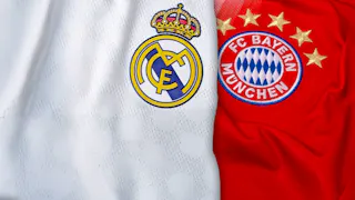 Nahaufnahme der Trikots von Real Madrid und FC Bayern München mit ihren Vereinslogos nebeneinander auf weißem und rotem Stoffhintergrund.