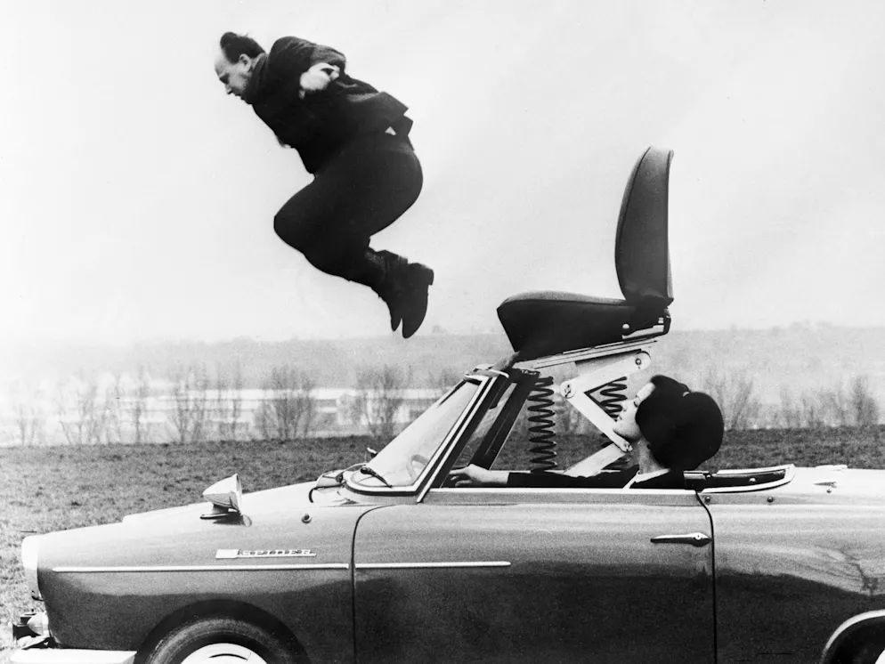 Aprilscherz-Fotos aus dem Bilderarchiv. Ein angebliches neues Autosystem soll Frauen ermöglichen, unangenehme Mitfahrer per Knopfdruck mit einem Schleudersitz aus dem Wagen zu befördern. Der Bericht ist ein Aprilscherz, der eine erfundene Vorführung dieser «Erfindung» in Zürich ankündigt.