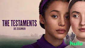 Eine junge Frau in brauner Tracht blickt ernst nach vorn, während hinter ihr zwei Frauen in grünen Roben und markanten Hauben durch einen Torbogen gehen.